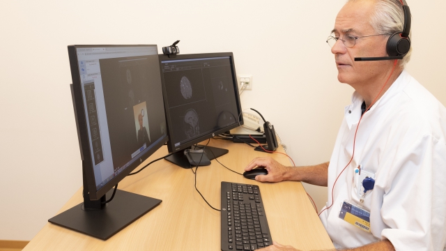 Neuroloog Pieter Vos aan het beeldbellen met een patiënt